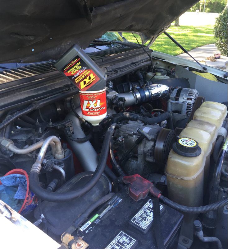 PolyDyn TX7 Engine Treatment bottle sitting on an engine during an oil change